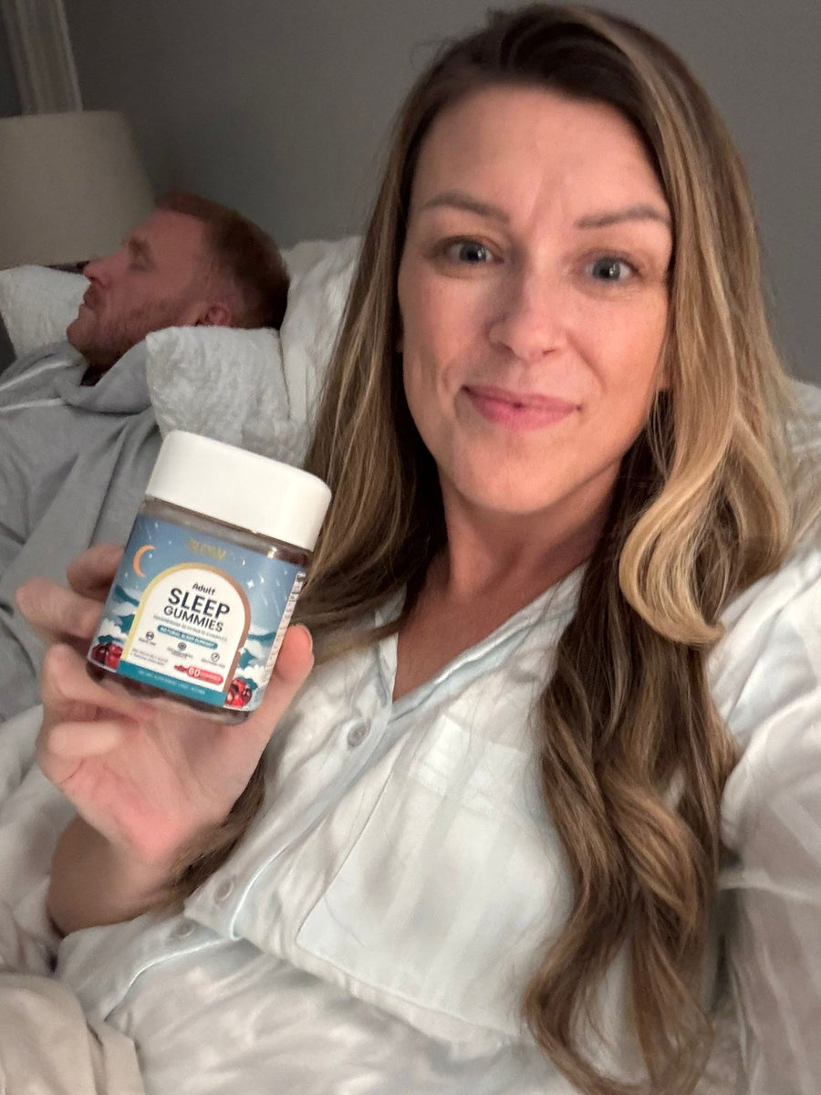 Customer holding Glowco Adults Sleep Gummies in bed